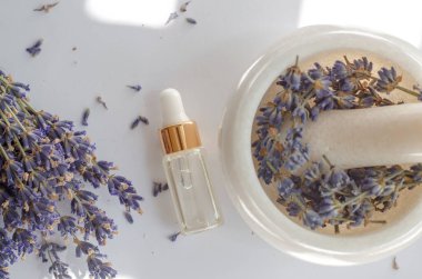 Lavanta yağı ve taze lavanta çiçekleriyle şeffaf şişe manzarası