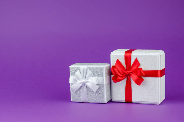 Big and small gift boxes on purple background