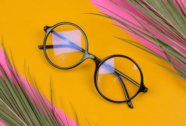 Stylowe Okrągłe Okulary Kolorowym Tle Liśćmi Palmy — Zdjęcie stockowe