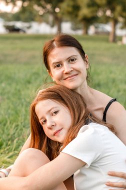 Portrait of a mother with her daughter in nature. Mother and daughter are having fun