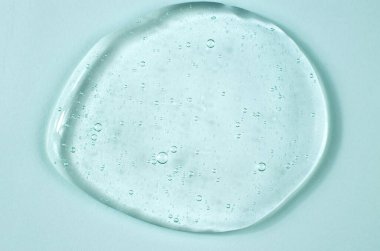 Transparent gel with air bubbles on a blue background. Cosmetics for body care. Laboratory research and development in cosmetology.
