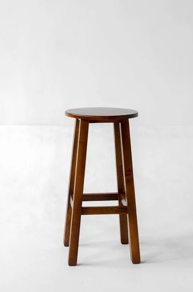 Brown wooden stool with four legs on a white background