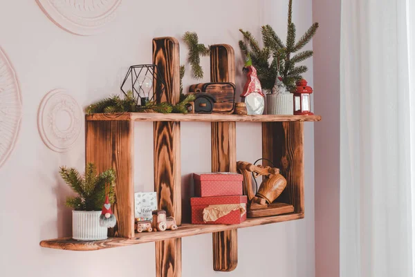 Christmas decor on a wall shelf in a bright room, selective focus