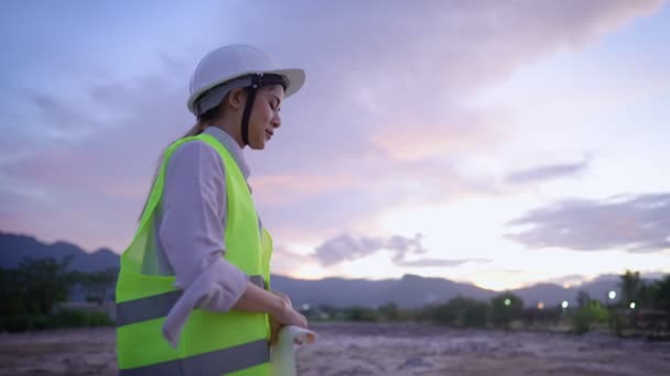 Junge Müde Bauarbeiterin Faltet Blaupause Während Sie Abends Arbeitskleidung Auf — Stockvideo