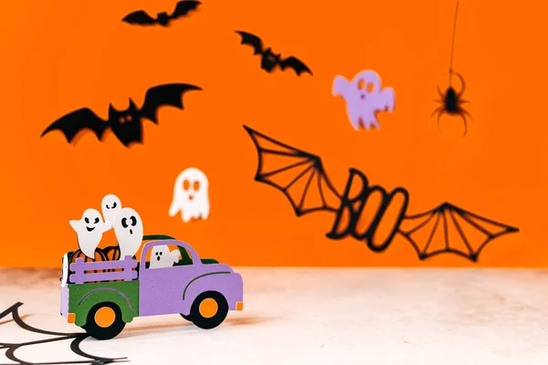 Happy halloween holiday concept. Halloween handmade paper decorations, spiders, ghosts in car, bats, boo text on orange background. Halloween festival party, greeting card mockup with copy space