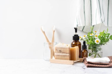 Doğal banyo ve spa aletleri. Sıfır sürdürülebilir yaşam tarzı konsepti. Bambu diş fırçası, doğal sabun, pamuk pedler, beyaz arka planda yeniden kullanılabilir şişelerde ev yapımı DIY güzellik ürünleri.