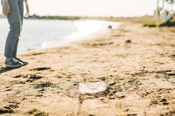 Eine gebrauchte Plastikflasche, die am Strand angespült wurde, verdeutlicht die weltweite Krise der Plastikverschmutzung. Umweltökologisches Konzept. — Stockfoto