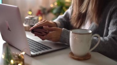 Kadın eli çantası, kredi kartı, hediyeler, kahve fincanı ve dizüstü bilgisayar. Noel tatilinde online alışveriş. Ev ofisinden serbest çalışan bir kız. Defter bilgisayarında daktilo eden bir kadın. Noel anları