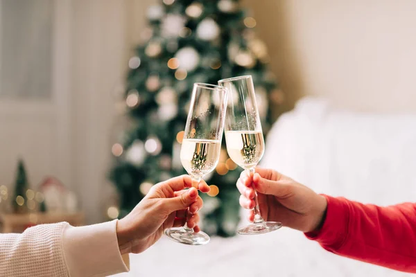 Hands of Family couple holding champagne glasses, close up. Celebrate New year after Christmas holidays. Home decor with Christmas tree — Stock Photo, Image