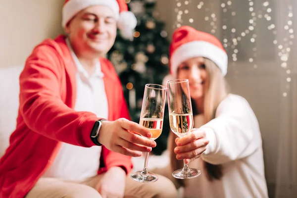 Family couple man and woman holding champagne glasses, close up. Celebrate New year after Christmas holidays. Home decor with Christmas tree — Stock Photo, Image