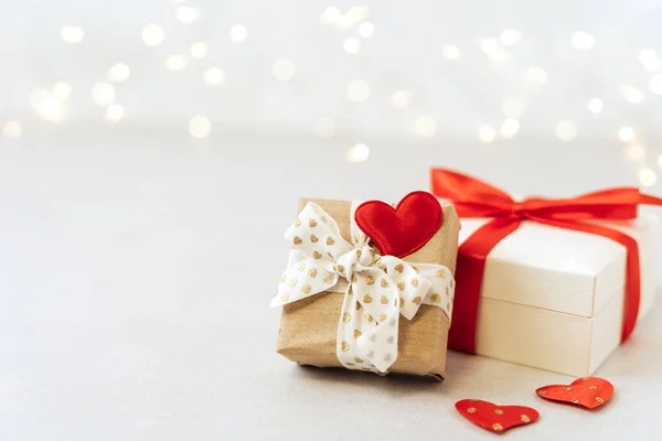 Gift or present box with red bow and heart shape on lights background. Copy space for text and design. Valentine day gift. Banner for Christmas, hew year, birthday concept — Stock fotografie