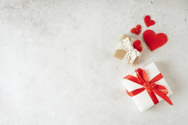 Arkaplanda hediyeler, kalplerde beton gri arka planda yazılar için boş alan var. Sevgililer Günü konsepti. Anneler Günü konsepti. Tebrik kartı. Uzayı kopyala Düz yatış, üst görünüm