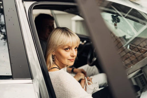 An adult mature happy romantic couple in love outdoors in car. A blonde caucasian man and woman spend time together. Senior wife and husband — Stock Photo, Image