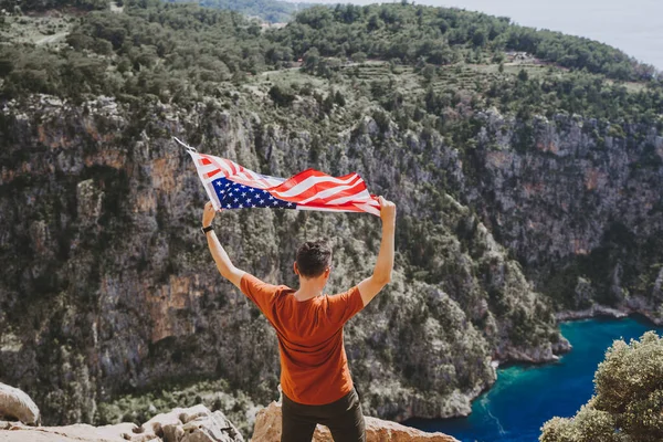 Junger Mann Steht Auf Einer Felswand Und Schwenkt Die Flagge — Stockfoto