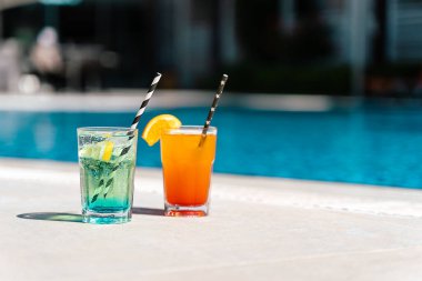 Havuz kenarında tropik köpüklü limonata kokteyli. Portakallı bardaklar ve nane limonlu meyve kokteylleri. Otel havuzunun yanında bedava yaz alkolü. Merhaba yaz tatili