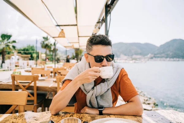 Junger Mann Mit Sonnenbrille Trinkt Kaffee Einer Straße Draußen Meer — Stockfoto