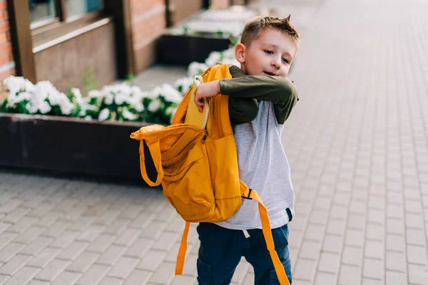 学校に戻る かわいい子供のパッキングバックパック ノートパッドを保持し 学校に行くトレーニング本 バッグを持った少年生徒 小学生は授業に行く 子供は街の外を歩く — ストック写真