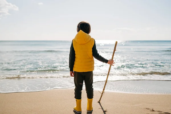 Boy Yellow Rubber Boots Playing Stick Sand Beach School Kid —  Fotos de Stock