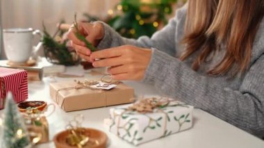 Noel hediyelerini paketleyen kadınların elleri, kapatın. Dekor elemanları ve ögeleri olan beyaz masada hazırlıksız hediyeler Noel veya Yeni Yıl Kutu Paketi.