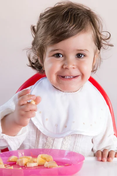 Baby flicka äter frukt — Stockfoto