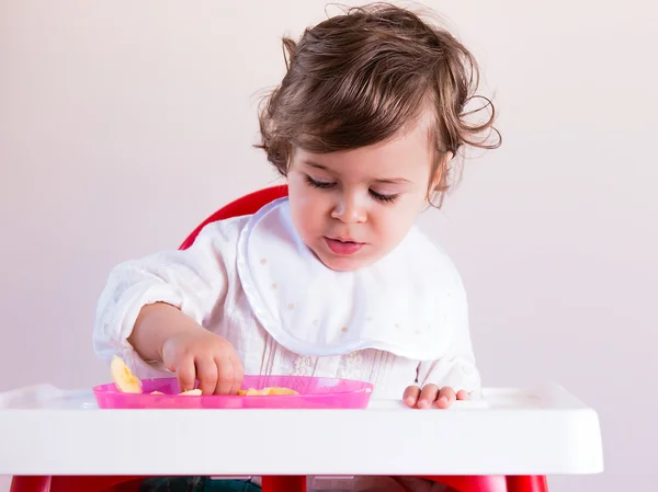 Baby flicka äter frukt — Stockfoto