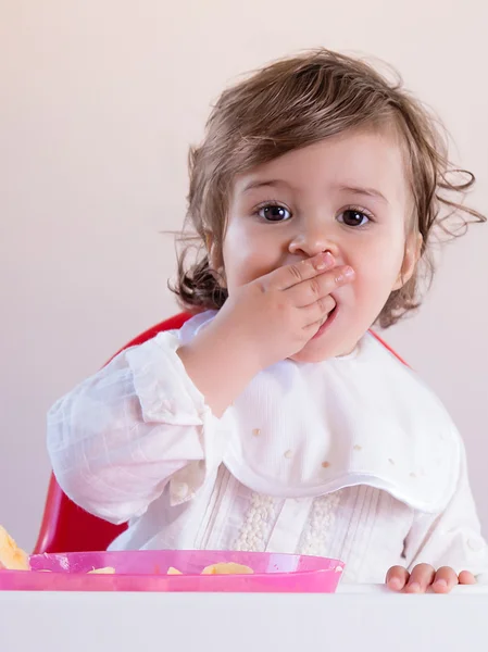 Baby flicka äter frukt med händerna — Stockfoto