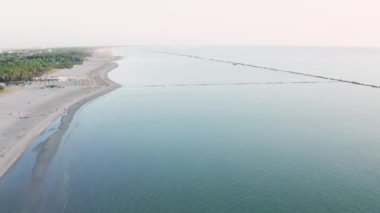 Şemsiyeli ve gazeli kumlu sahil manzarası. Lido Adriano kasabası, Adriyatik kıyısı, Emilia Romagna, İtalya..