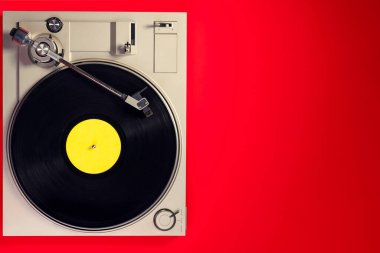 Kırmızı masadaki vinil plaklı gramofon, üst görünüm ve kopyalama alanı, eski tarz için bölünmüş ton.