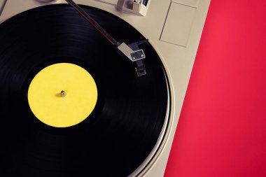 Kırmızı masadaki vinil plaklı gramofon, üst görünüm ve kopyalama alanı, eski tarz için bölünmüş ton.
