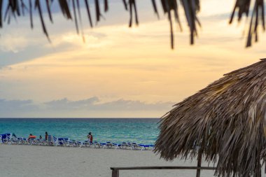 Turistler gün batımında Varadero kumsalında dinlenirler. Küba.