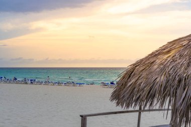 Turistler gün batımında Varadero kumsalında dinlenirler. Küba.