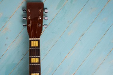 Ahşap arkaplandaki akustik gitarın yukarıdan görüntüsü, boşluğu kopyala.