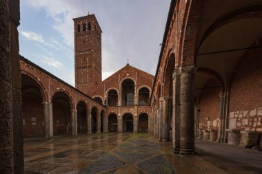Saint Ambrogio kilise tuğlası bina çan kuleleri, avlu, kemerler, mavi gökyüzü ve bulutlar, Milan, Lombardy, İtalya
