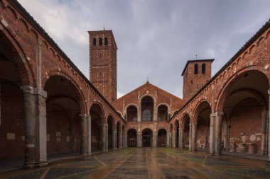 Saint Ambrogio kilise tuğlası bina çan kuleleri, avlu, bulutlu günde kemerler, Milan, Lombardy, İtalya