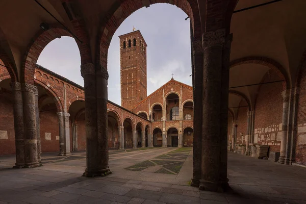 Saint Ambrogio kilise tuğlası bina çan kuleleri, avlu, bulutlu günde kemerler, Milan, Lombardy, İtalya