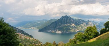 Panorama at Lake Iseo and Mount Corna Trentapassi at sunny day with clouds. Bergamo, Lombardy, Italy.
