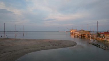 Gün batımında nehir kıyısındaki balıkçı kulübelerinin hava manzarası, 