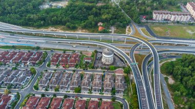 Yeşil asfalt yolu olan yerleşim alanının havadan görüntüsü ve görüş açısının hemen üstündeki evler. Banliyö ve şehir merkezi manzarası. Emlak ve konut piyasası kavramı.