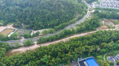 Yeşil asfalt yolu olan yerleşim alanının havadan görüntüsü ve görüş açısının hemen üstündeki evler. Banliyö ve şehir merkezi manzarası. Emlak ve konut piyasası kavramı.