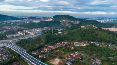 Yeşil asfalt yolu olan yerleşim alanının havadan görüntüsü ve görüş açısının hemen üstündeki evler. Banliyö ve şehir merkezi manzarası. Emlak ve konut piyasası kavramı.
