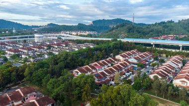 Yeşil asfalt yolu olan yerleşim alanının havadan görüntüsü ve görüş açısının hemen üstündeki evler. Banliyö ve şehir merkezi manzarası. Emlak ve konut piyasası kavramı.