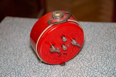 Çalar saati olan eski Sovyet masa saati. Konu kırmızı.