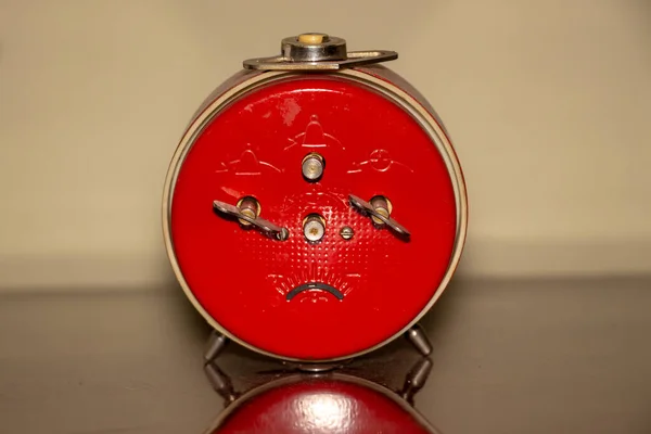 Old metal Soviet table clock with alarm clock. The subject is red
