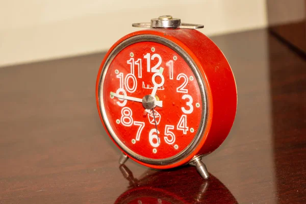 Old metal Soviet table clock with alarm clock. The subject is red