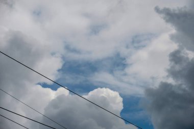 Mavi gökyüzü ve gri bulutlar güzel havada ormandaki ağaçların arka planında