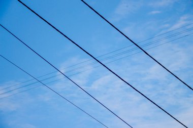 Mavi gökyüzünün arka planında elektrik hatları