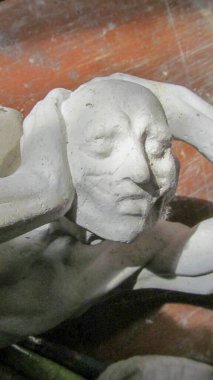 Düşünce içinde ellerini başının arkasında tutan bir adamın heykeli.