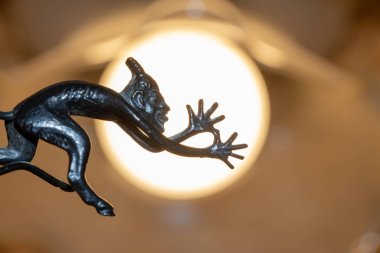 Dilini gösteren kuyruğu olan şeytanın küçük metal heykeli.