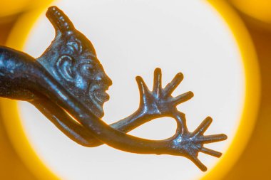 Dilini gösteren kuyruğu olan şeytanın küçük metal heykeli.