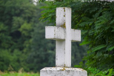 Beyaz çimlerin üzerinde beyaz beton bir Hıristiyan haçı
